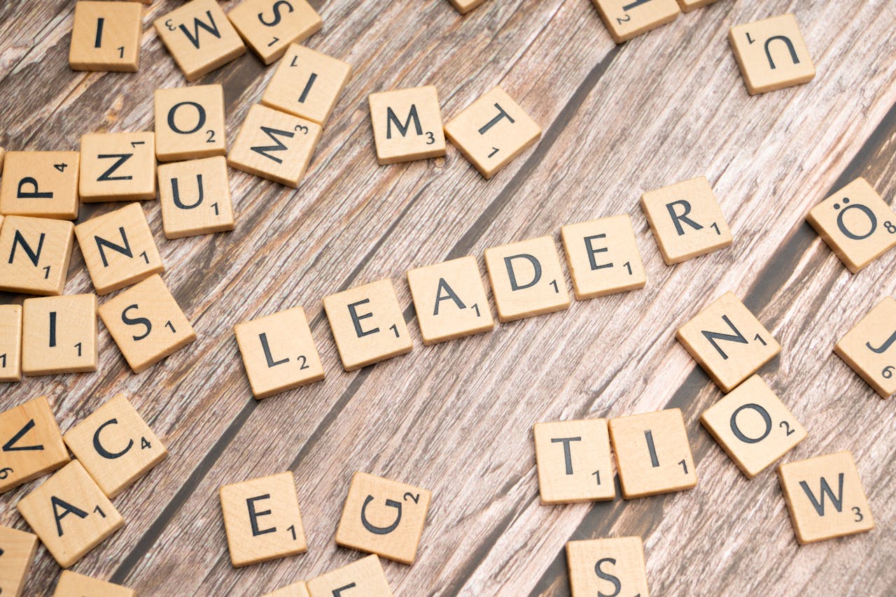 Wooden Scrabble tiles on a table spelling 'Leader' symbolize leadership and strategy.